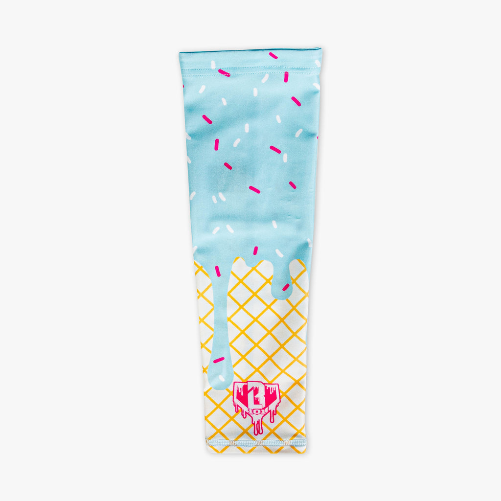 Ice cream arm sleeve laid flat on a white background featuring a light blue dripping frosting and pink and white sprinkle print over a waffle cone design with a BL101 logo near the wrist