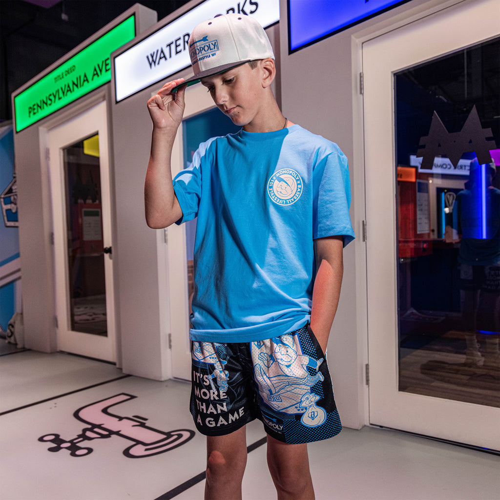 Adult model wearing graphic tee with “BL101 x Monopoly” design