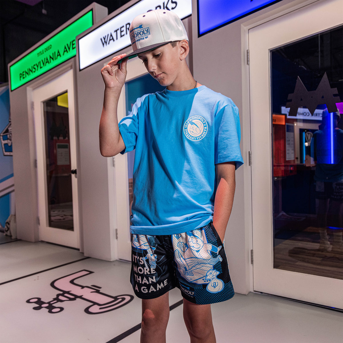 Adult model wearing graphic tee with “BL101 x Monopoly” design