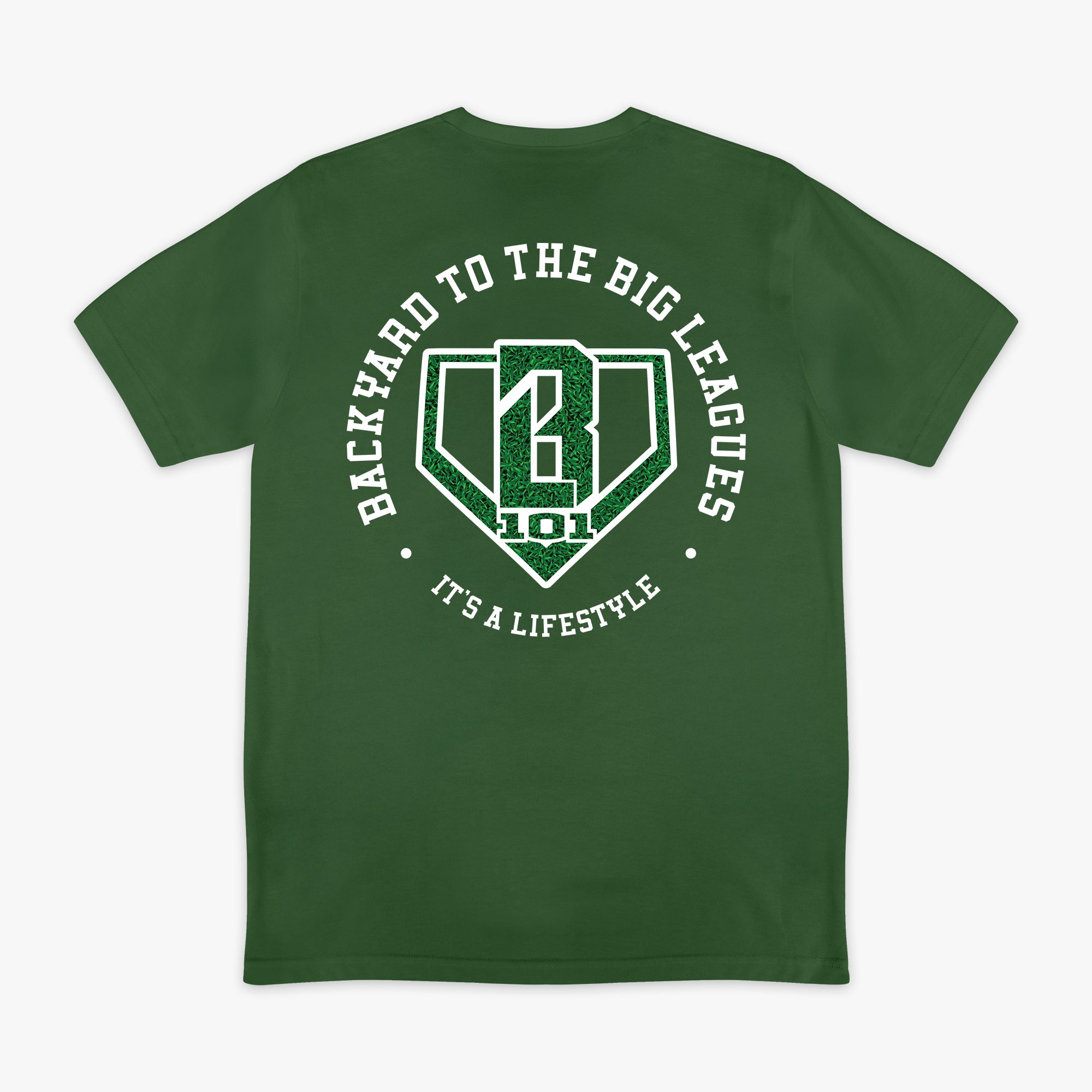 Image 1: Back flat lay of the BL101 Backyard to the Big Leagues forest green tee, featuring a circular "It's a Lifestyle" graphic with a grass-textured BL101 logo on a white background.