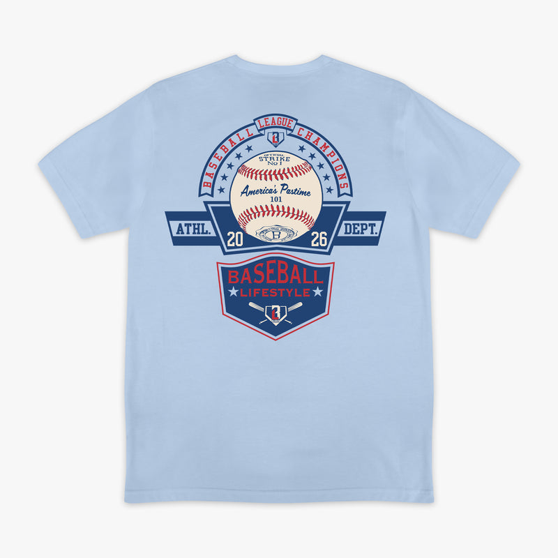 ack flat lay of the BL101 Baseball League Champions light blue tee, featuring a vintage-style "America's Pastime" baseball and Baseball Lifestyle shield graphic on a white background.