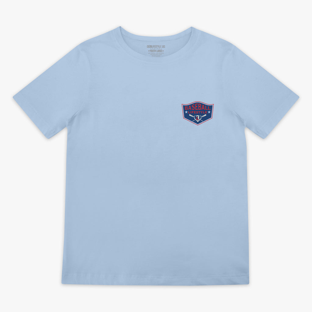 Front flat lay of the BL101 Baseball League Champions light blue tee, showing the Baseball Lifestyle shield chest logo on a white background.