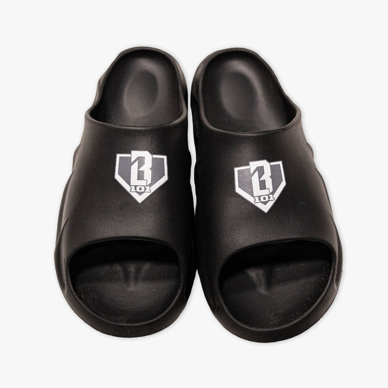 Top-down view of BL101 black slides with a gray and white home plate logo on a white background.