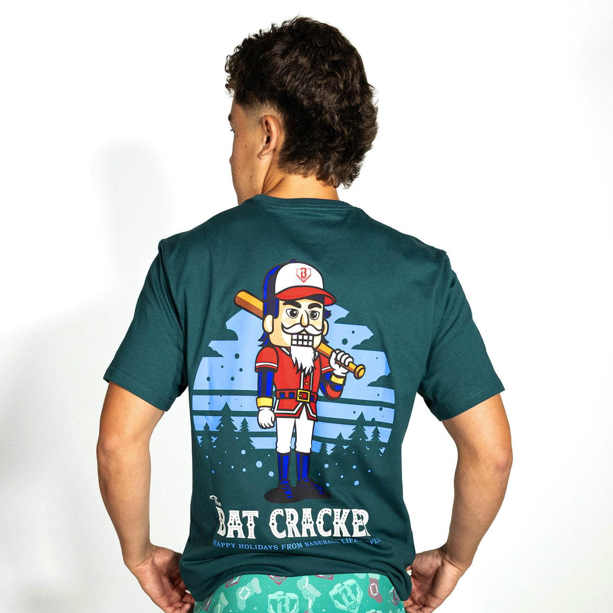 Adult model wearing teal graphic tee with "Bat Cracker" design