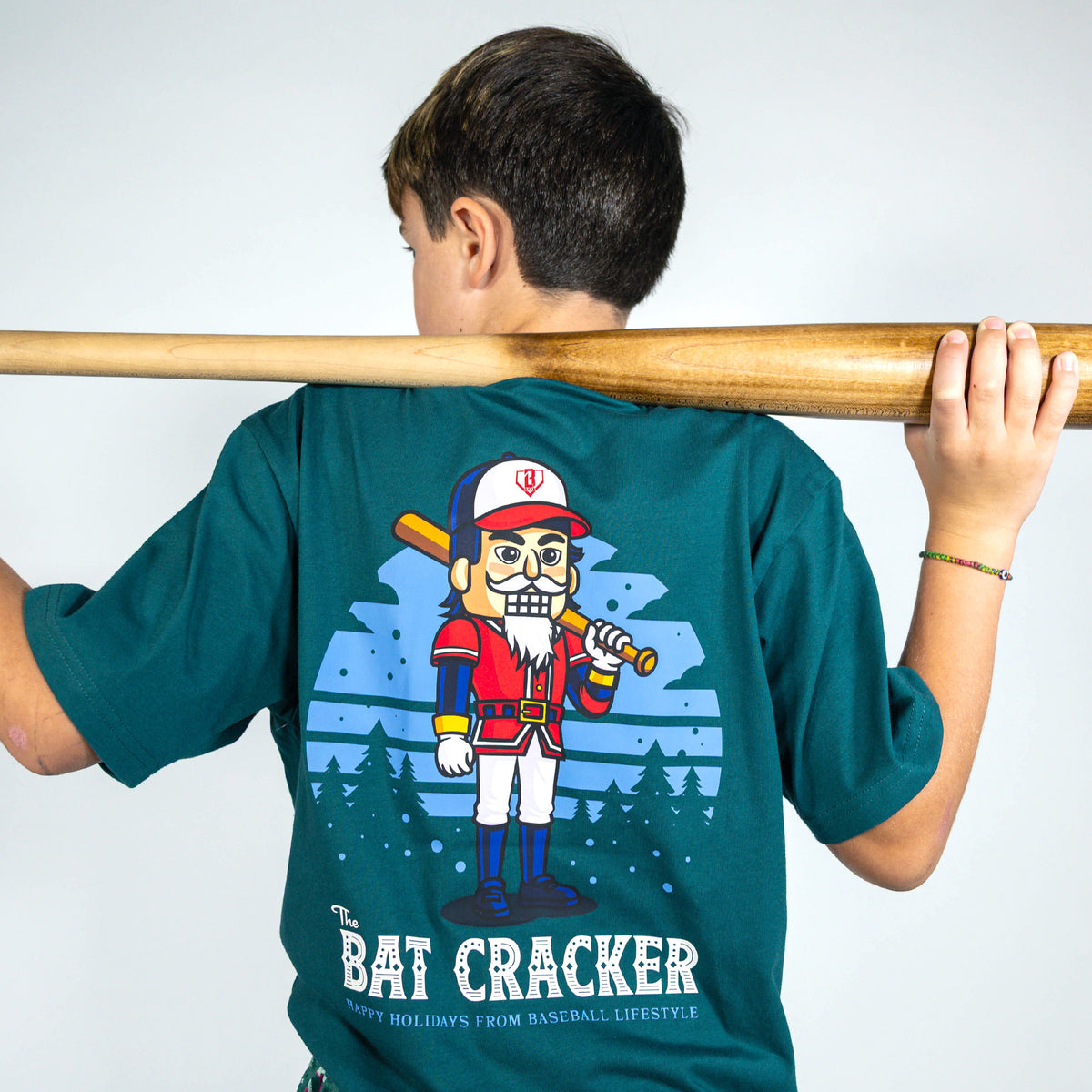 Youth model wearing teal youth graphic tee with "Bat Cracker" design
