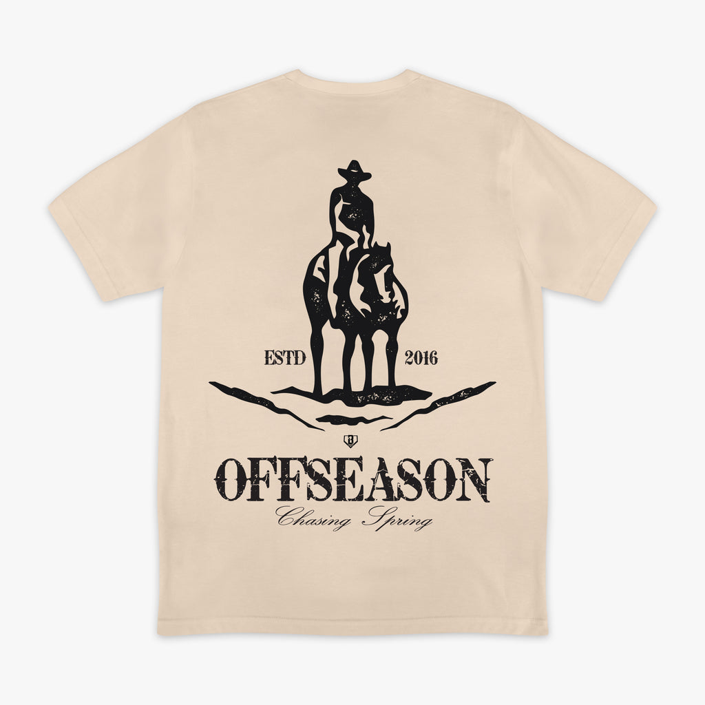 Beige t-shirt with a graphic of a person on a horse and text 'Offseason Chasing Spring' on a white background