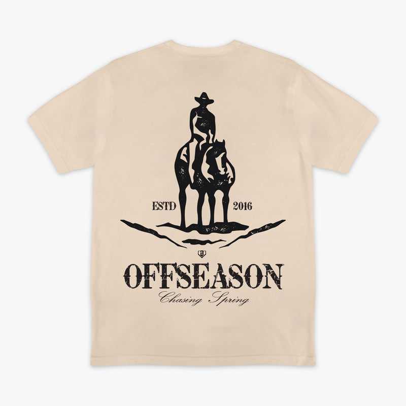 Beige t-shirt with a graphic of a person on a horse and text 'Offseason Chasing Spring' on a white background