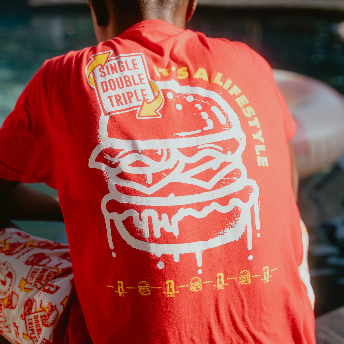 Youth model wearing youth graphic tee with "Burger" design