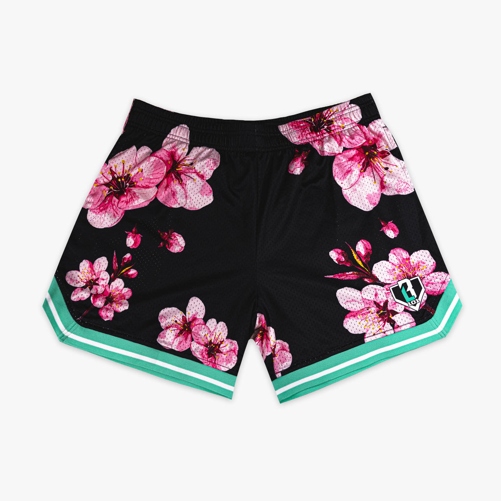 Black BL101 mesh shorts with an all-over pink cherry blossom print and teal and white striped hem, flat lay front view