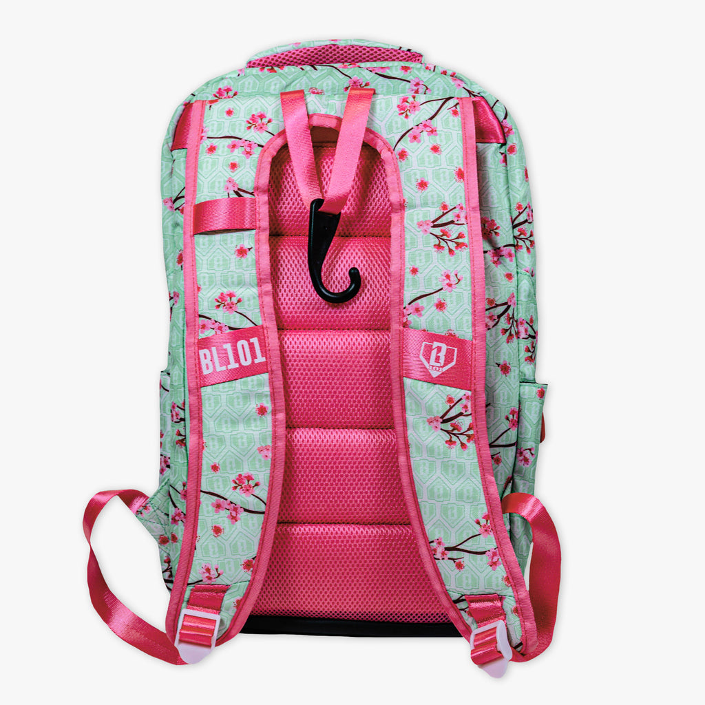 Adult model wearing green backpack with "Cherry Blossoms SZN 2" design