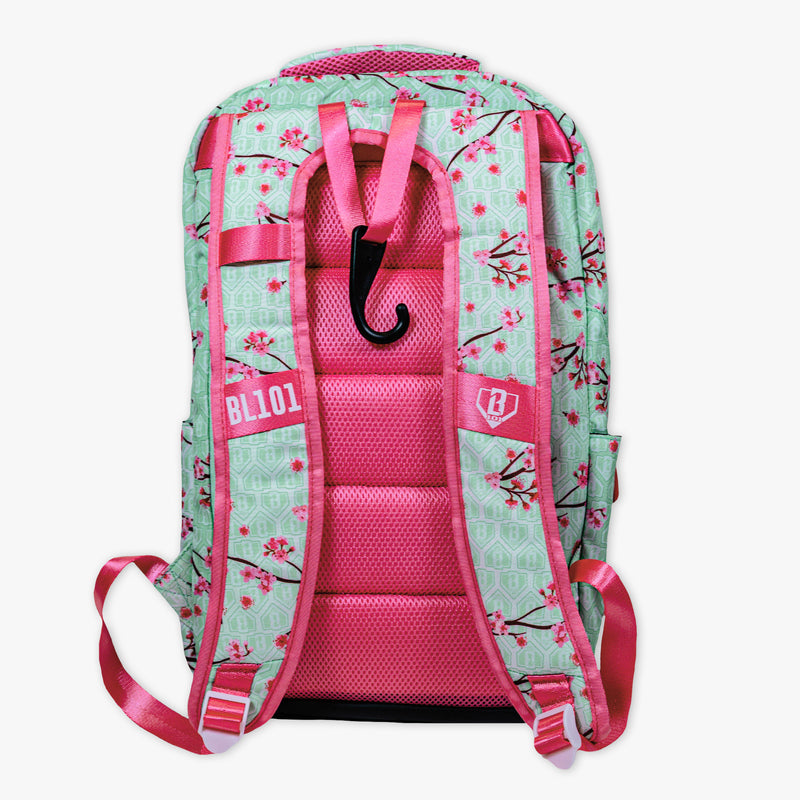 Adult model wearing green backpack with "Cherry Blossoms SZN 2" design