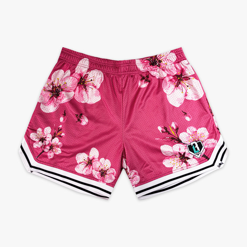 Pink BL101 mesh shorts with an all-over cherry blossom print and white and black striped hem, flat lay front view