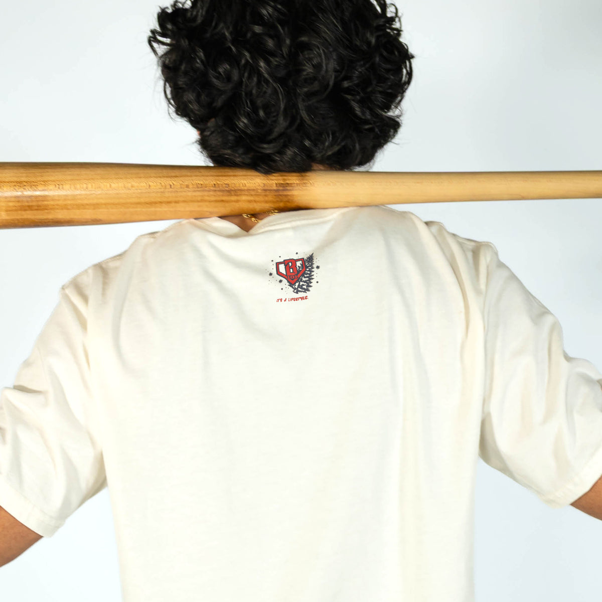 Adult model wearing white graphic tee with "Deck The Halls" design