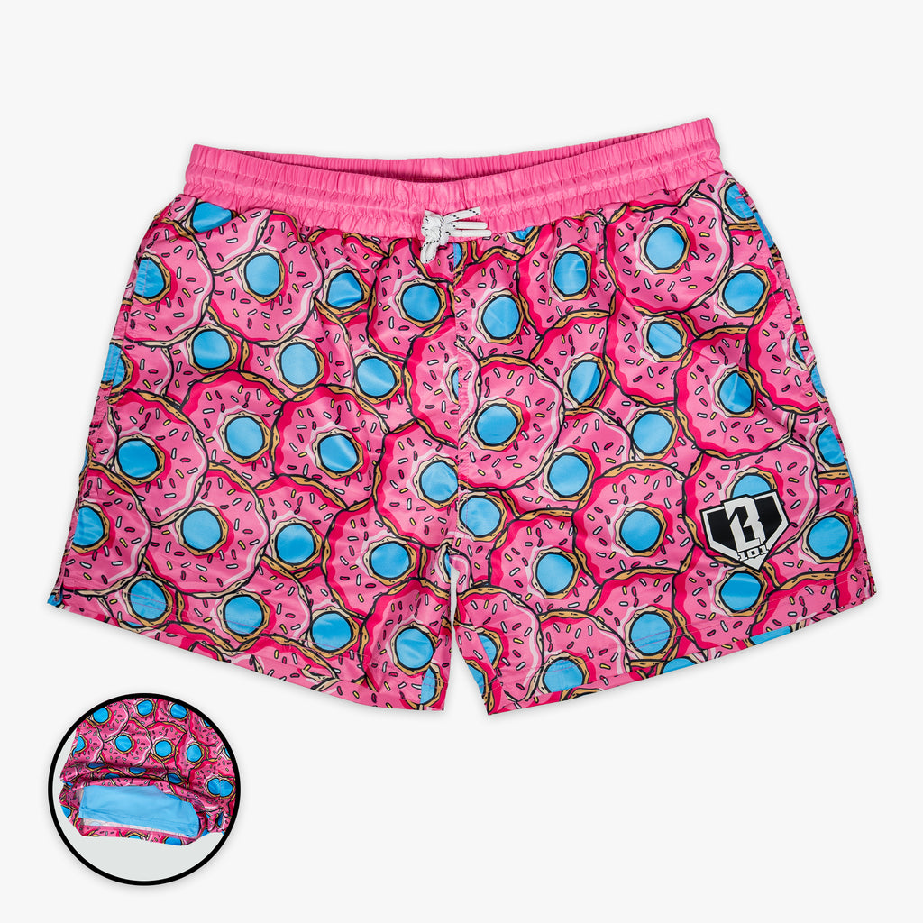 Pink swim shorts with donut pattern on a white background