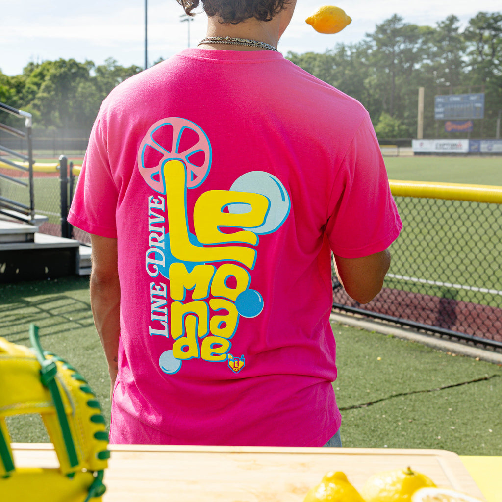 Adult model wearing pink graphic tee with "Electric Lemonade" design