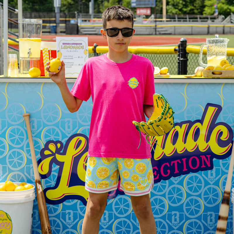 Youth model wearing pink youth graphic tee with "Electric Lemonade" design