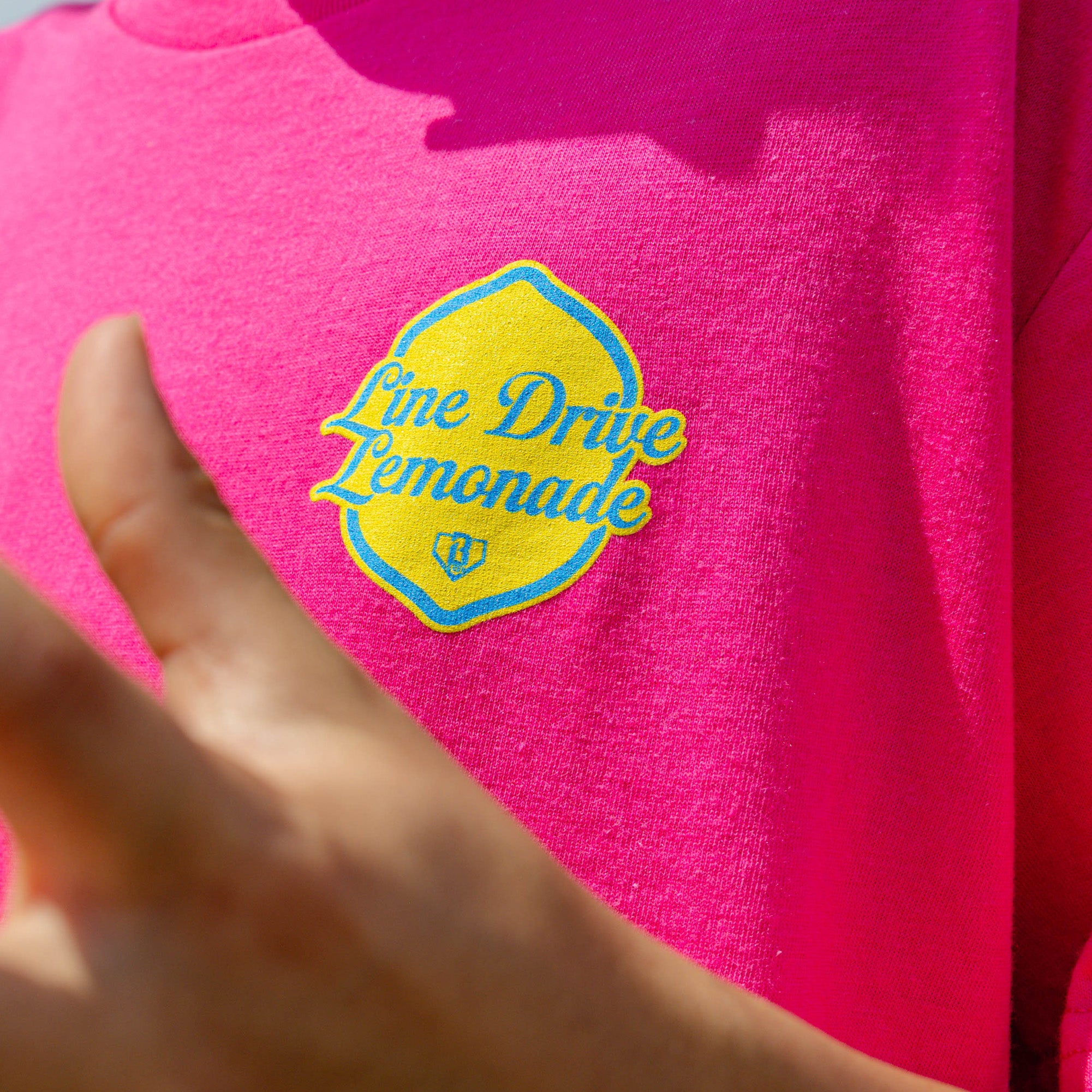 Youth model wearing pink youth graphic tee with "Electric Lemonade" design