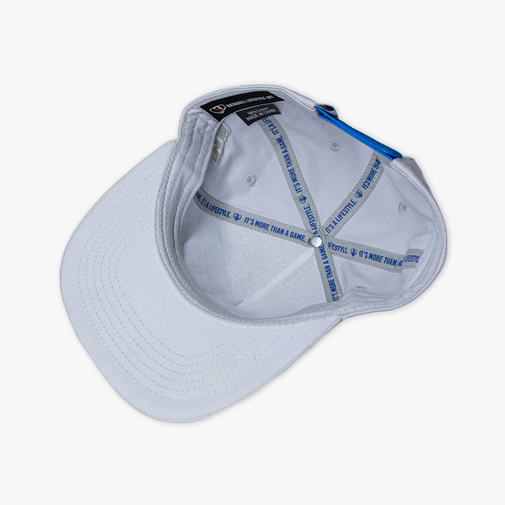 Interior overhead view of gray snapback hat showing white lining with blue It's More Than a Game It's a Lifestyle printed sweatband BL101 label and blue button on white background