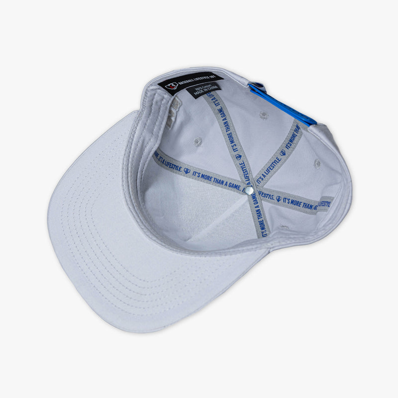 Interior overhead view of gray snapback hat showing white lining with blue It's More Than a Game It's a Lifestyle printed sweatband BL101 label and blue button on white background