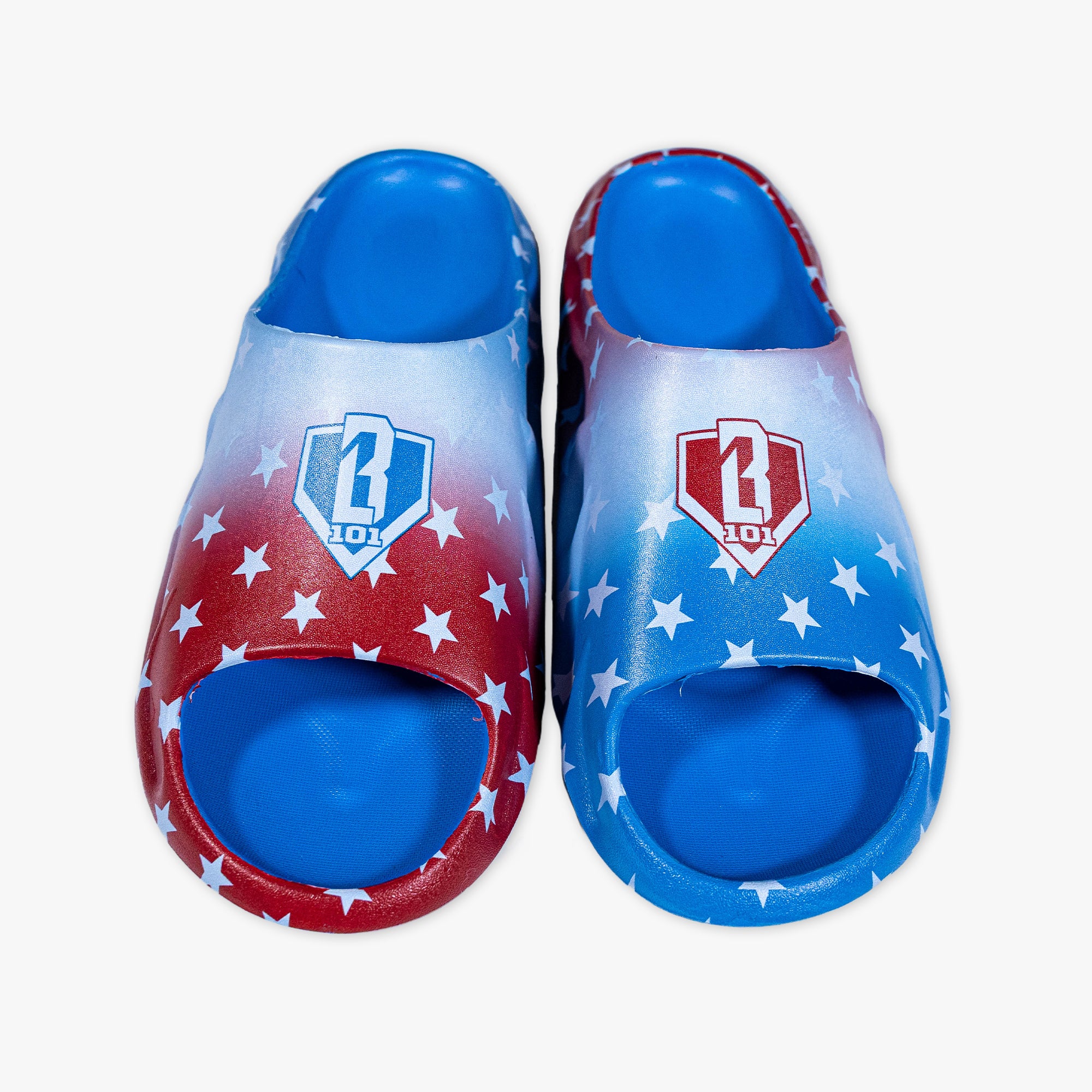 BL101 slides featuring a red, white, and blue star print with a gradient ombre design and BL101 home plate logo on each strap.