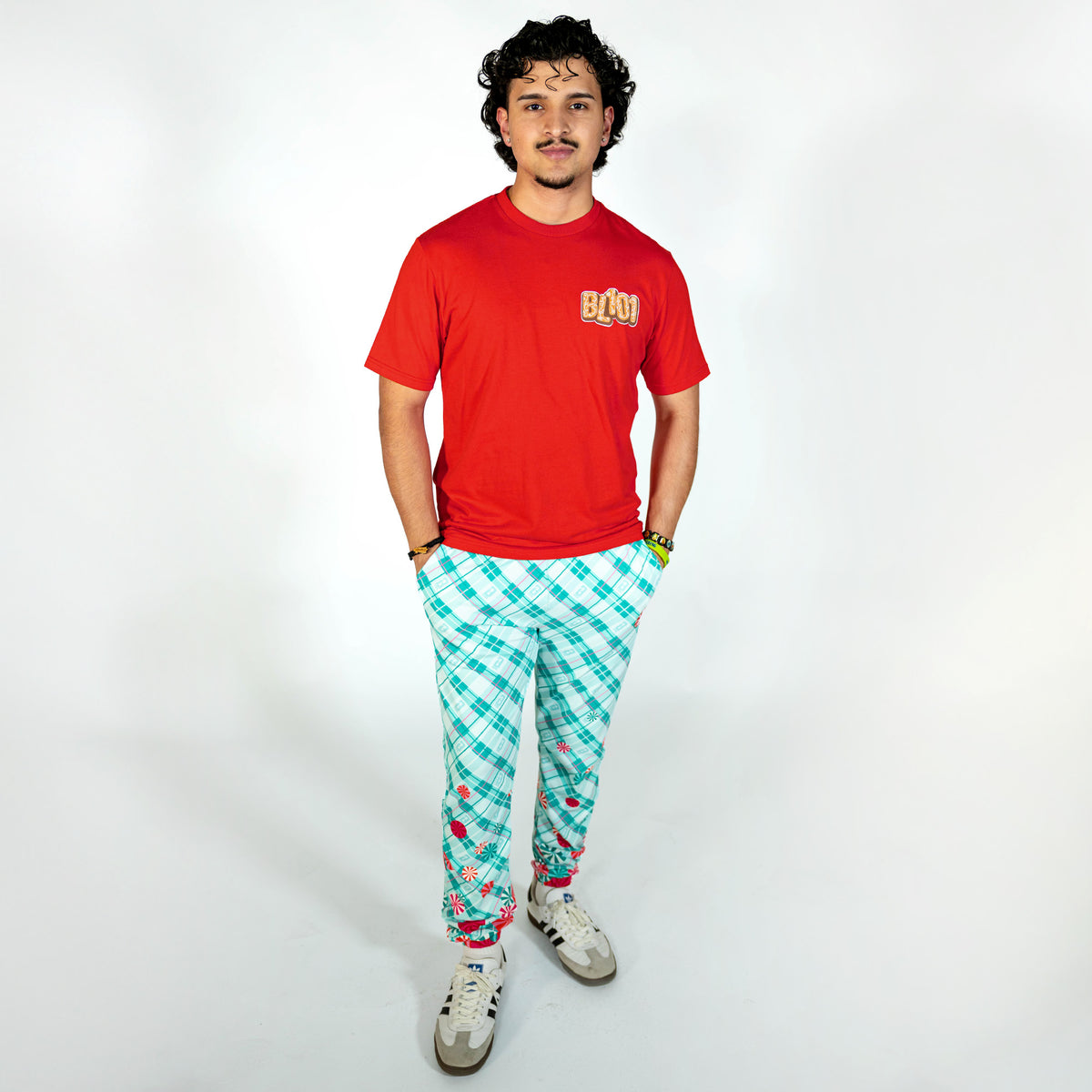 Adult model wearing red graphic tee with "Gingerbread Stadium" design