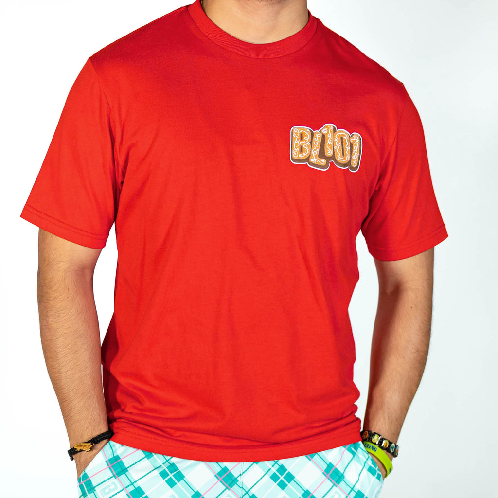 Adult model wearing red graphic tee with "Gingerbread Stadium" design