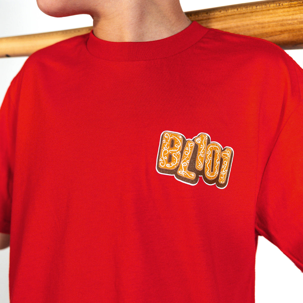 Youth model wearing red youth graphic tee with "Gingerbread Stadium" design