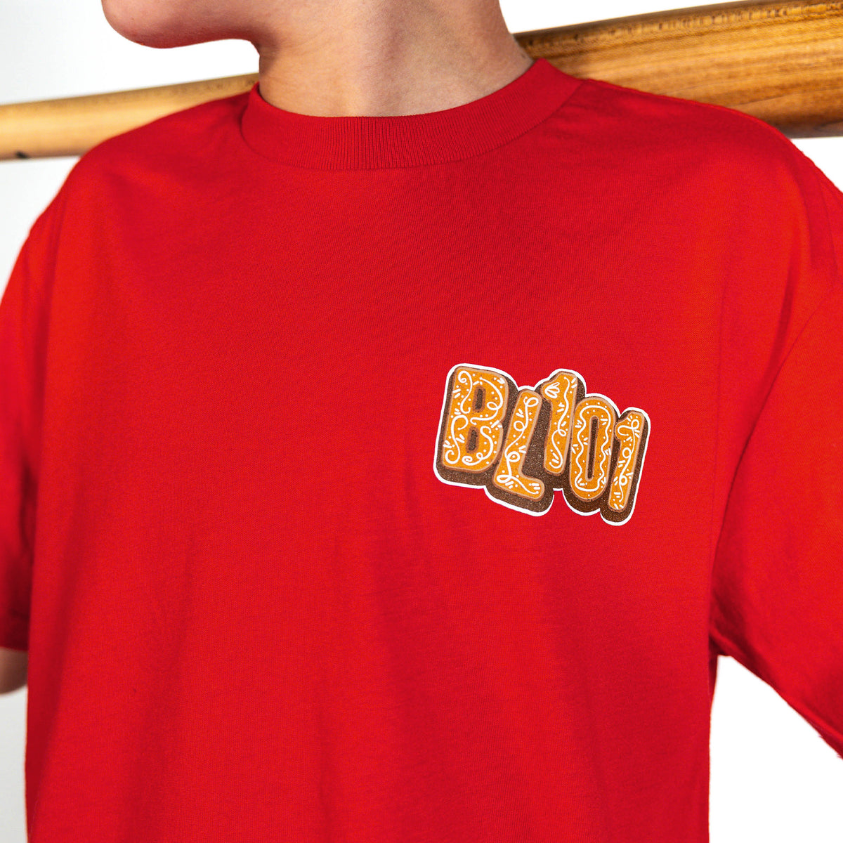 Youth model wearing red youth graphic tee with "Gingerbread Stadium" design