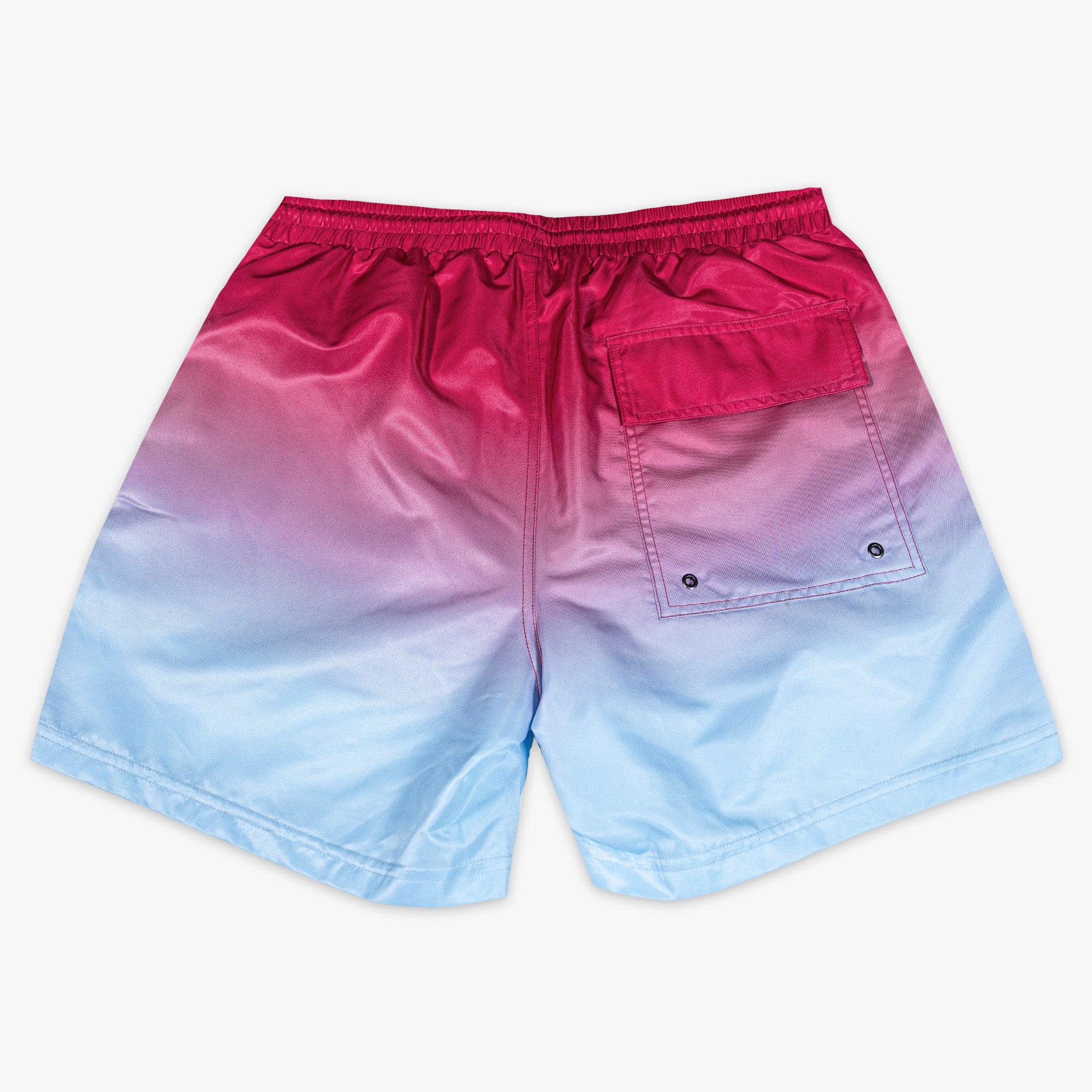 Back flat lay of BL101 pink to blue ombre swim trunks showing the cargo-style snap pocket.