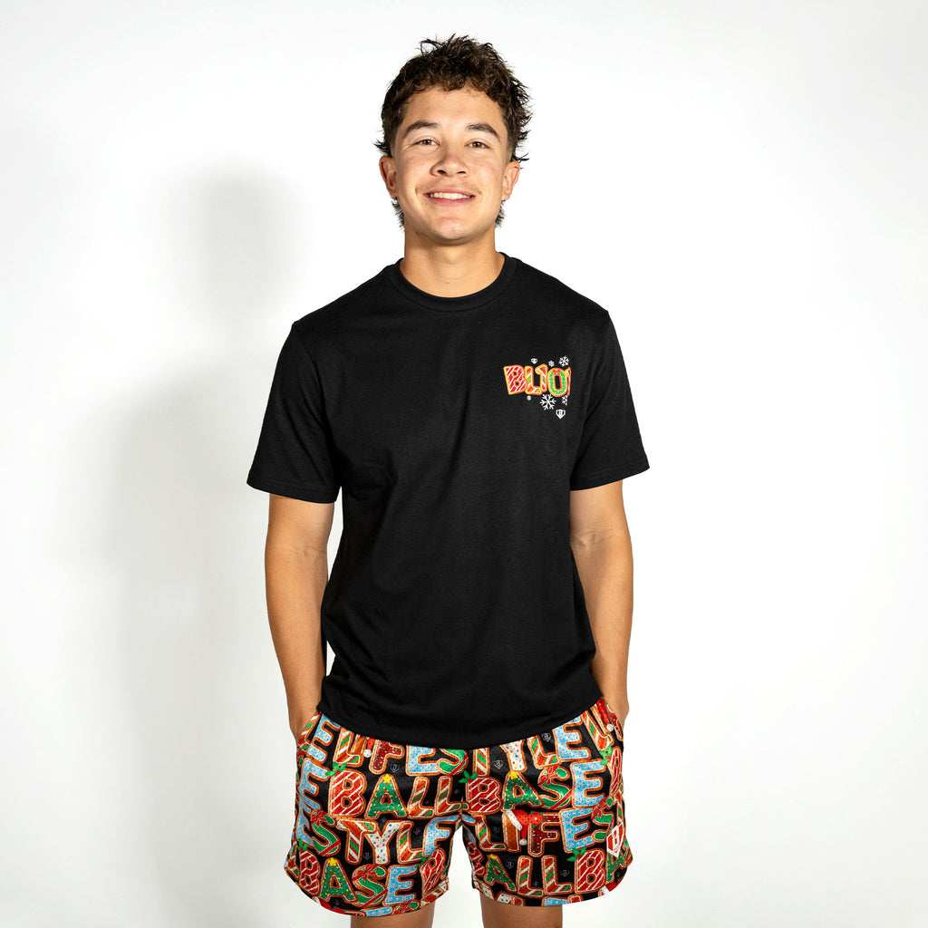 Adult model wearing black graphic tee with "Holiday Cookie" design