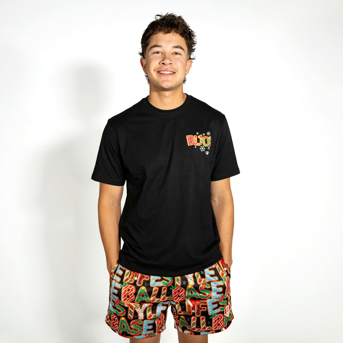 Adult model wearing black graphic tee with "Holiday Cookie" design