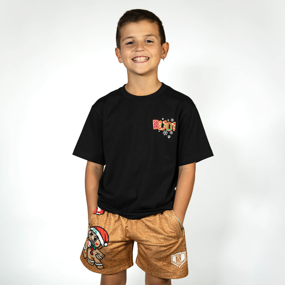 Youth model wearing black youth graphic tee with "Holiday Cookie" design