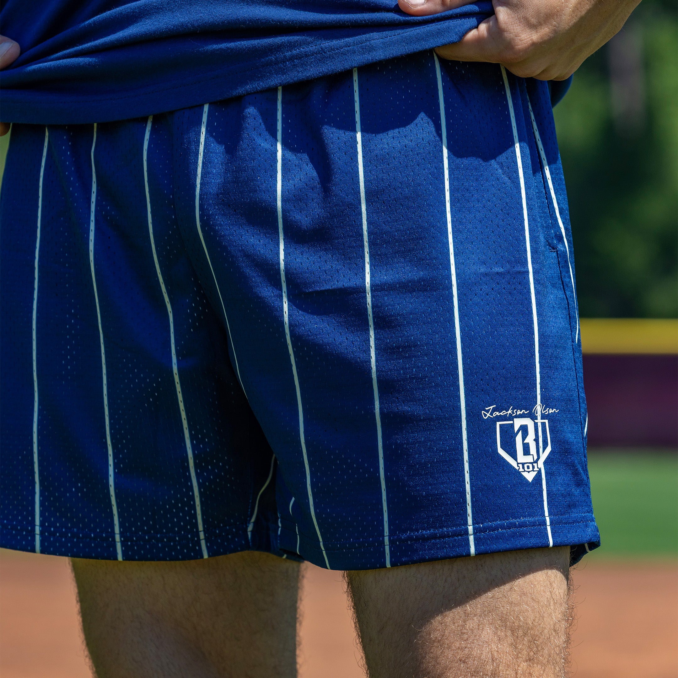 Person wearing blue striped shorts with beige waistband and white BL101 logo