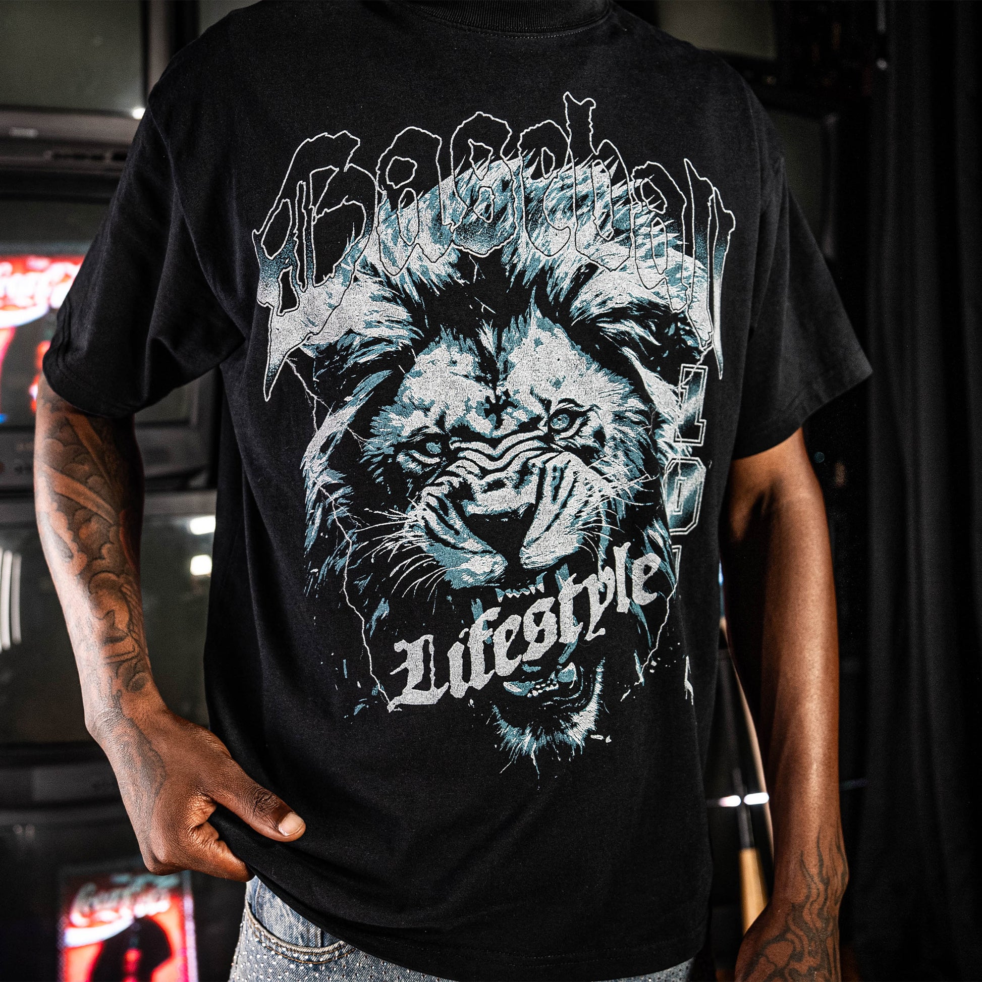 Person wearing a Black t-shirt with blue lion graphic and 'Baseball Lifestyle' text 