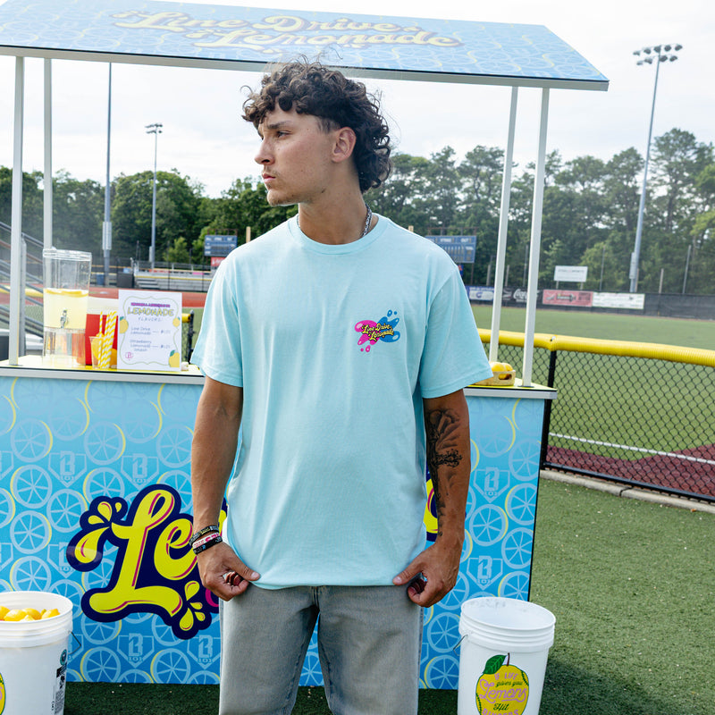Adult model wearing blue graphic tee with "Lemon Burst" design