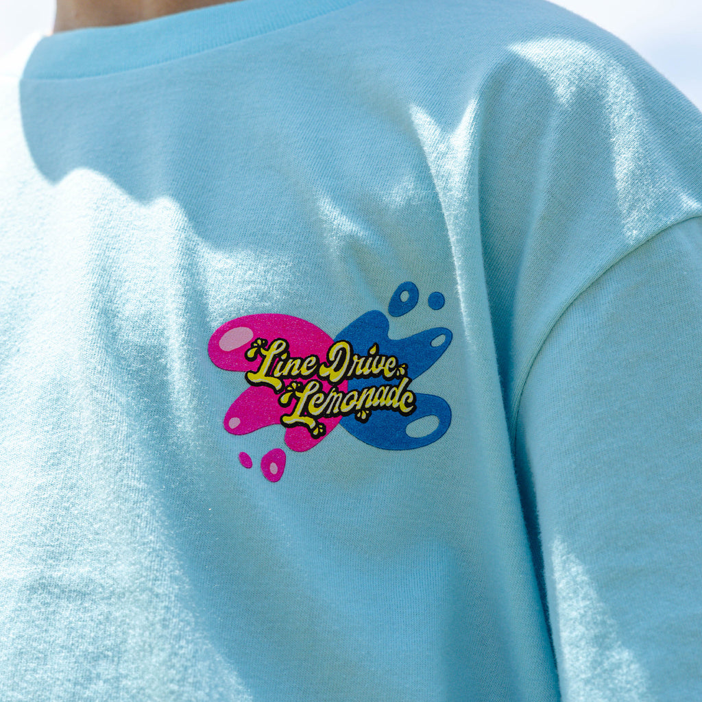 Youth model wearing blue youth graphic tee with "Lemon Burst" design
