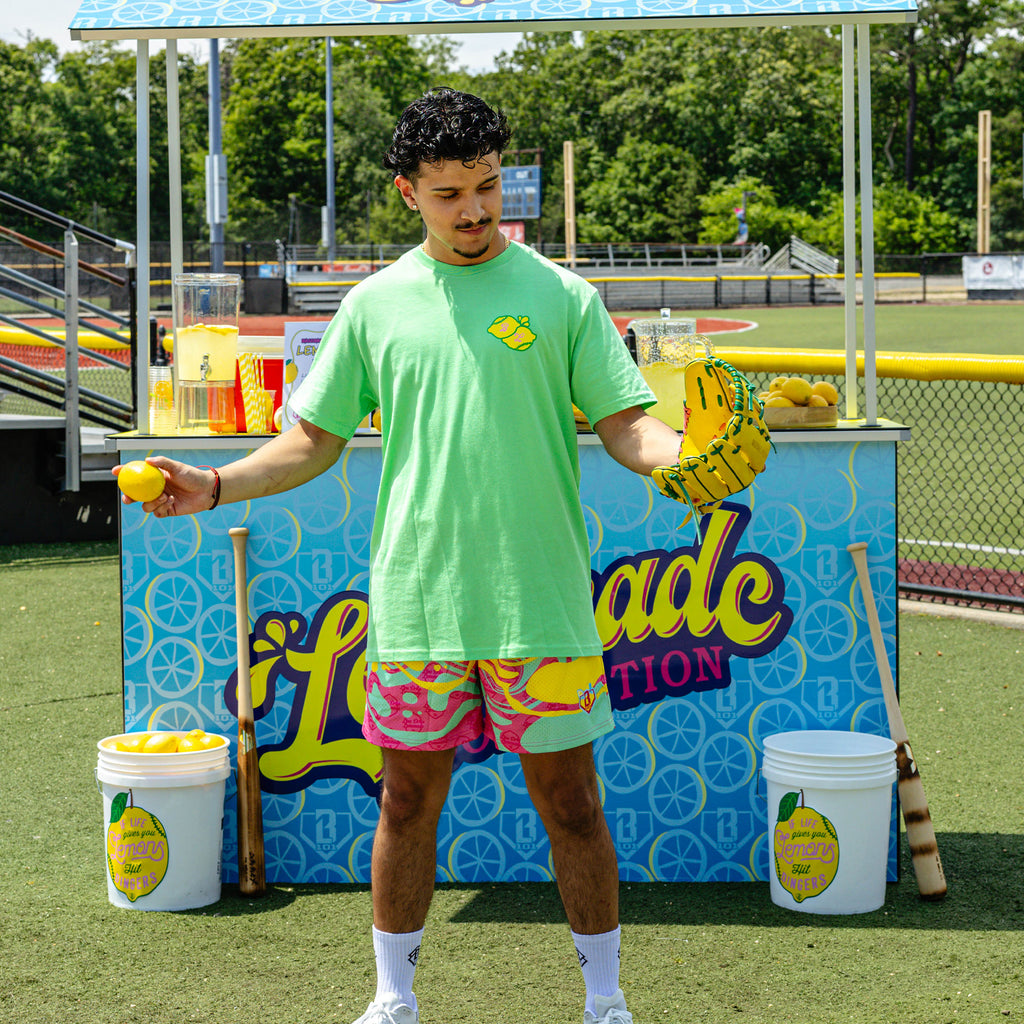 Adult model wearing green graphic tee with "Lemon Dingers" design