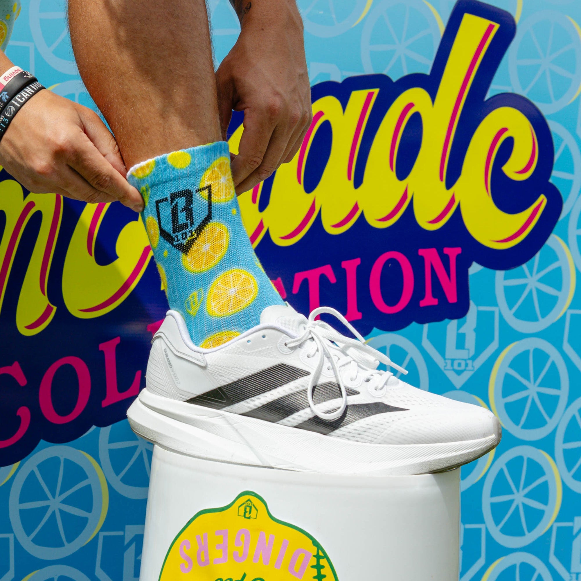Adult model wearing multi-color socks with "Lemonade Performance 3-Pack" design