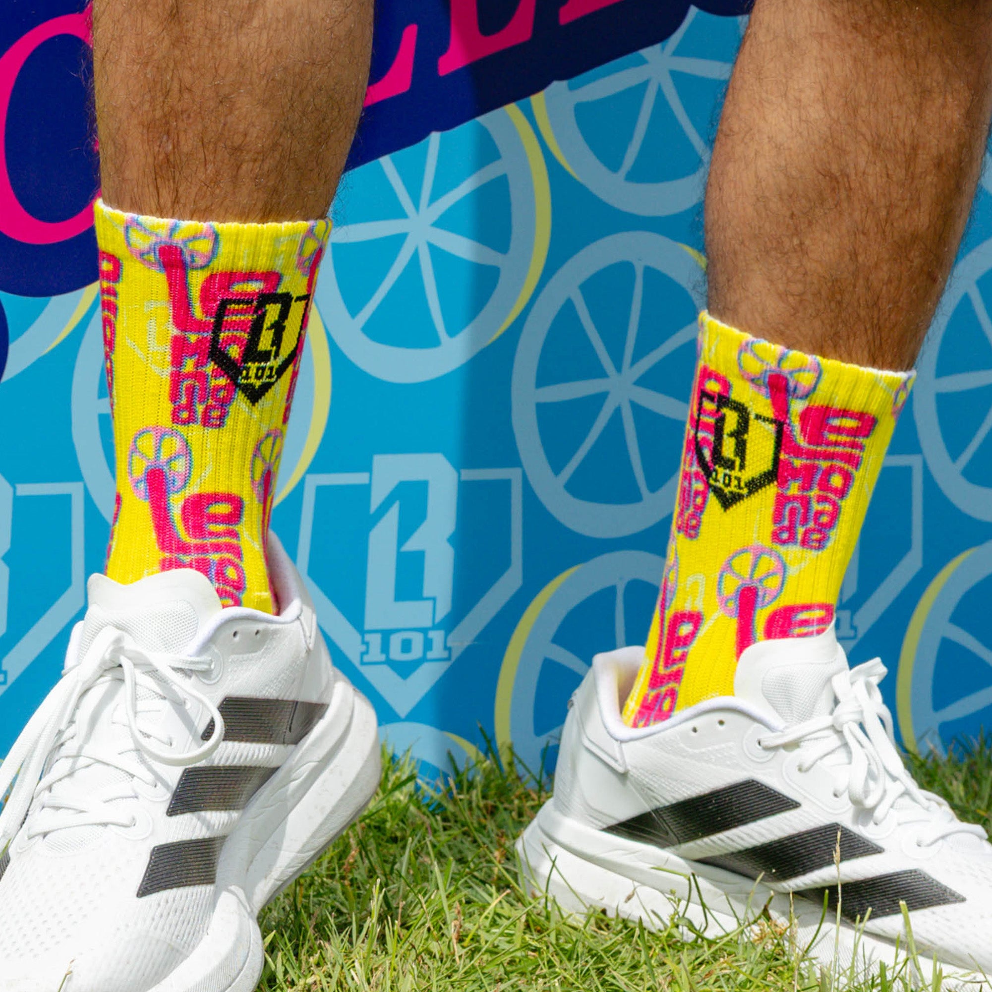 Adult model wearing multi-color socks with "Lemonade Performance 3-Pack" design