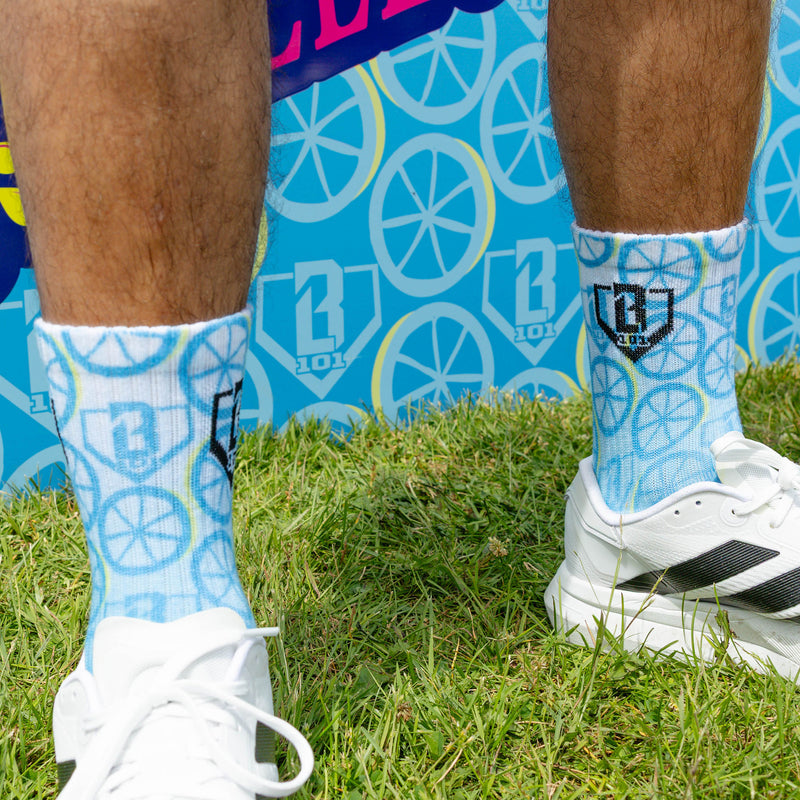 Adult model wearing multi-color socks with "Lemonade Performance 3-Pack" design