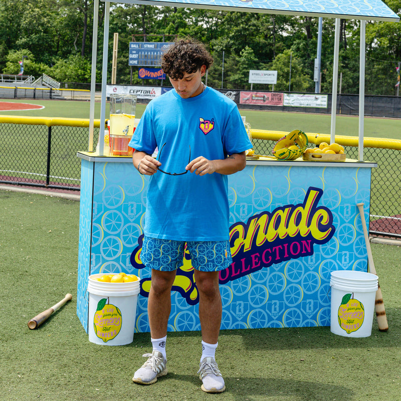 Adult model wearing blue graphic tee with "Lemonade" design