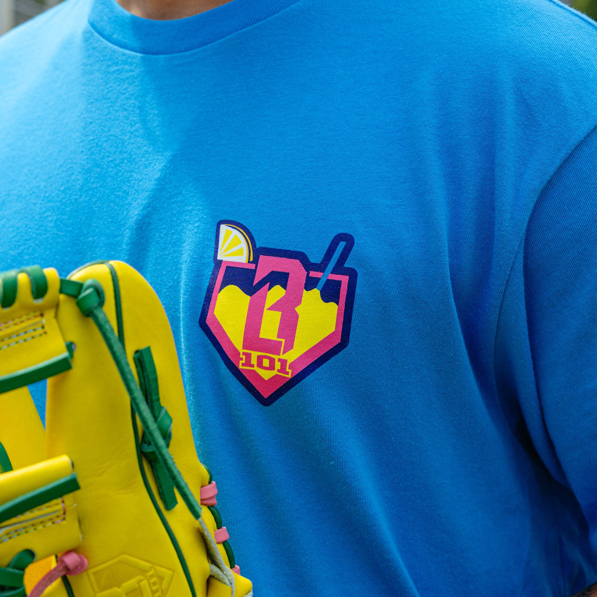 Adult model wearing blue graphic tee with "Lemonade" design