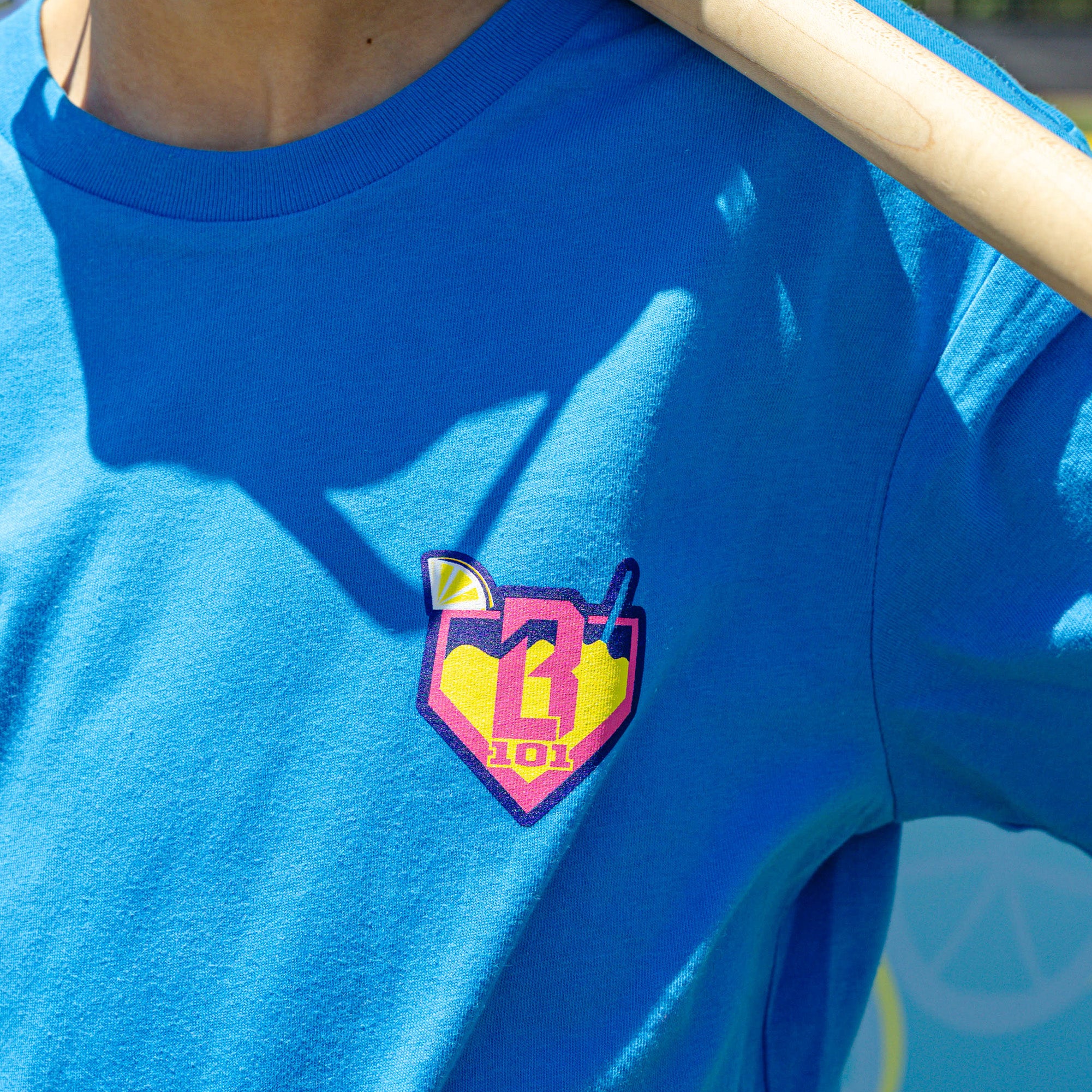 Youth model wearing blue youth graphic tee with "Lemonade" design