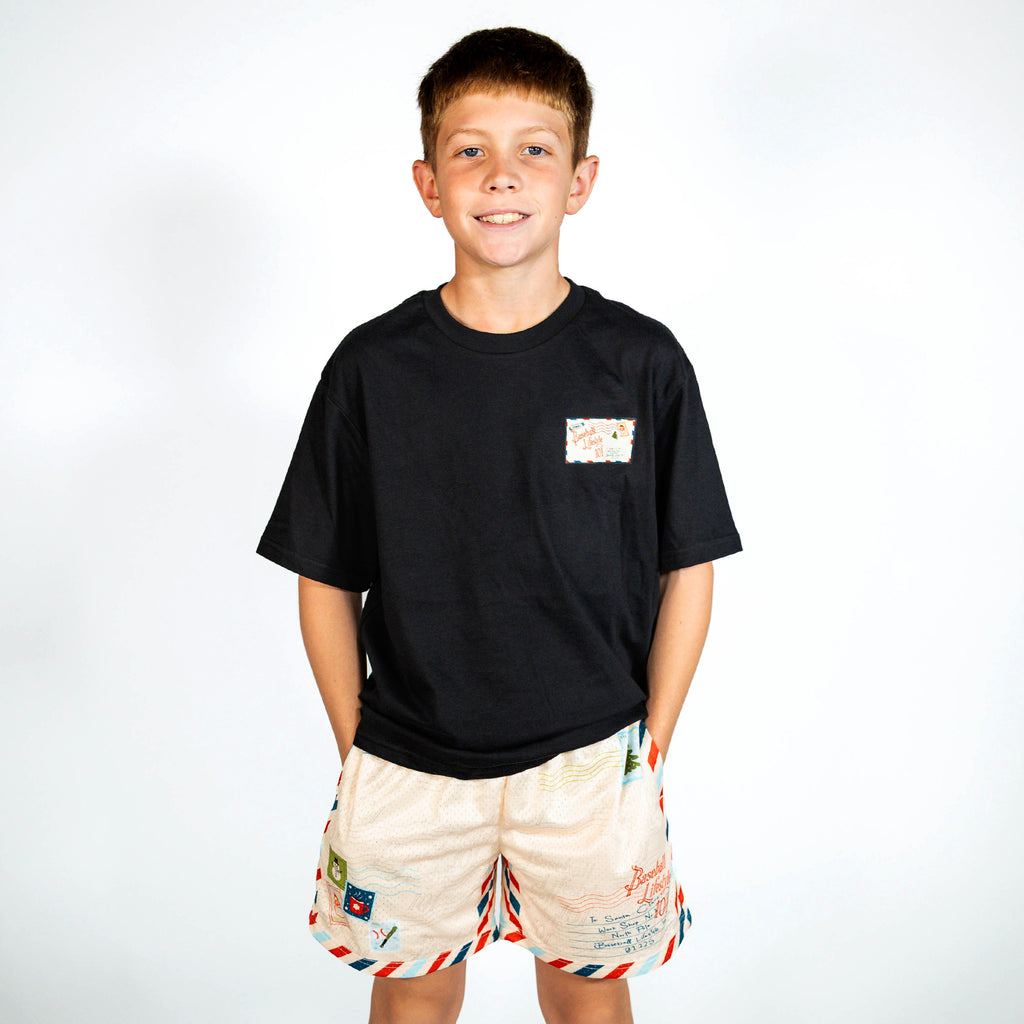 Youth model wearing black youth graphic tee with "Letter To Santa" design