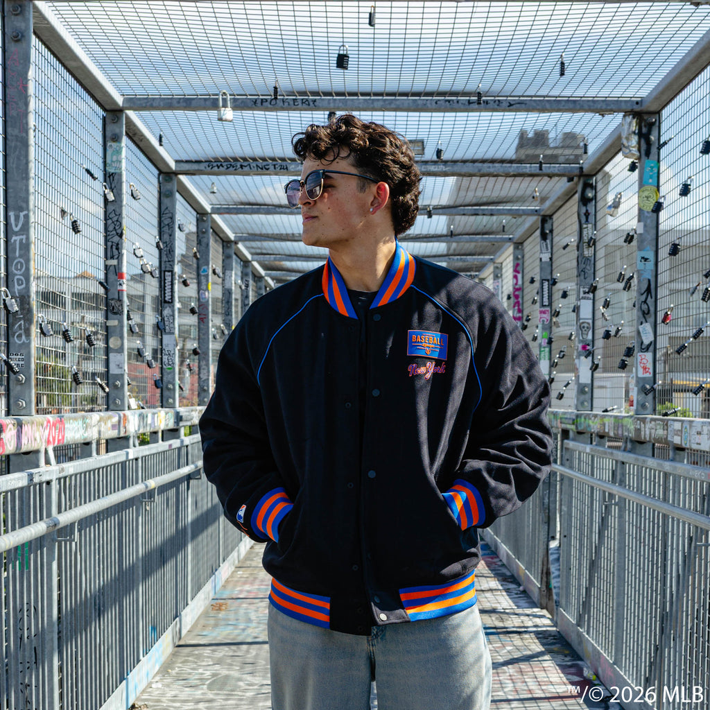 Adult model wearing black New York Mets Stadium bomber jacket