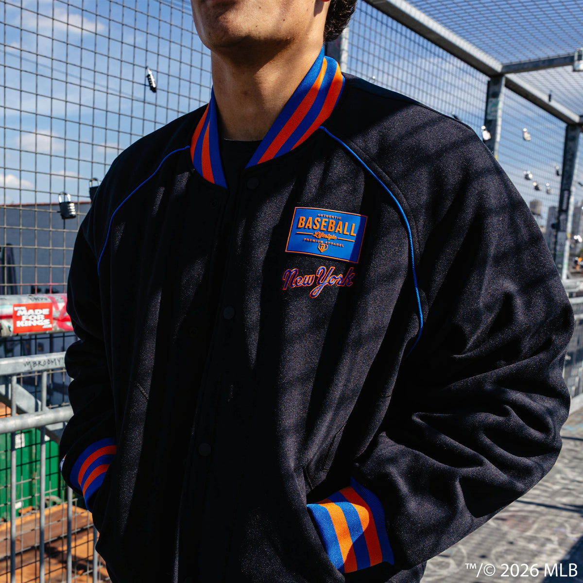Adult model wearing black New York Mets Stadium bomber jacket