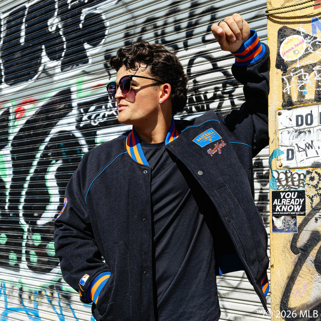 Adult model wearing black New York Mets Stadium bomber jacket