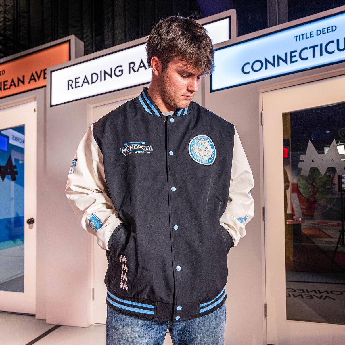 Youth model wearing youth jacket with “Monopoly MVP Varsity Jacket” design