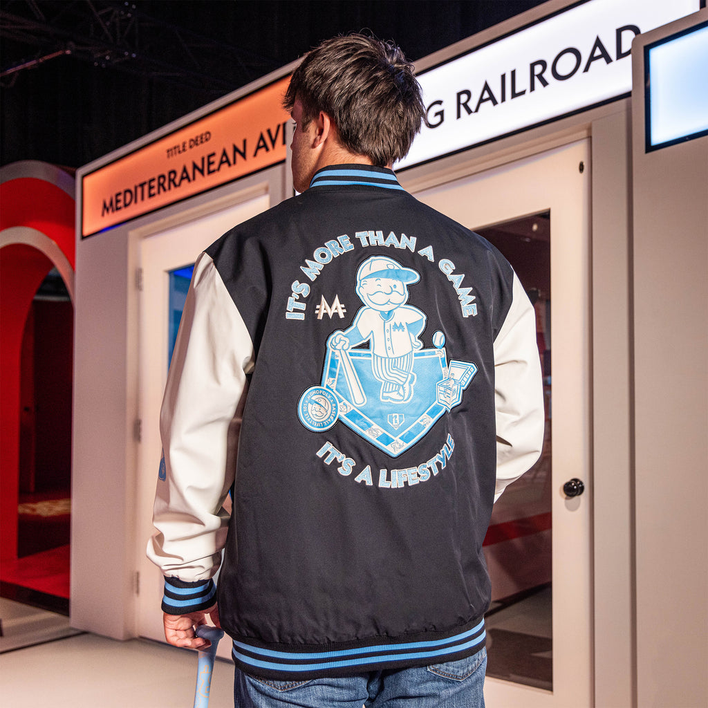 Youth model wearing youth jacket with “Monopoly MVP Varsity Jacket” design