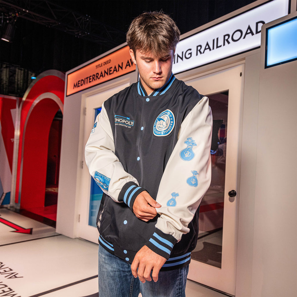 Youth model wearing youth jacket with “Monopoly MVP Varsity Jacket” design